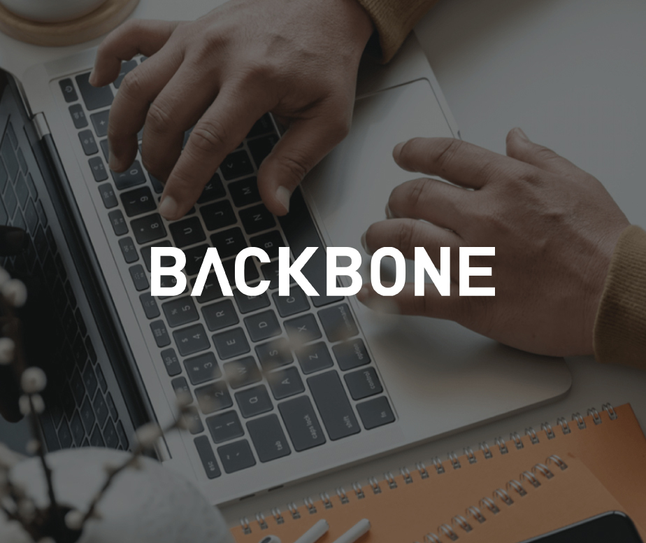 Picture of a man's hands writing on a keyboard laptop with the Backbone's logo on top