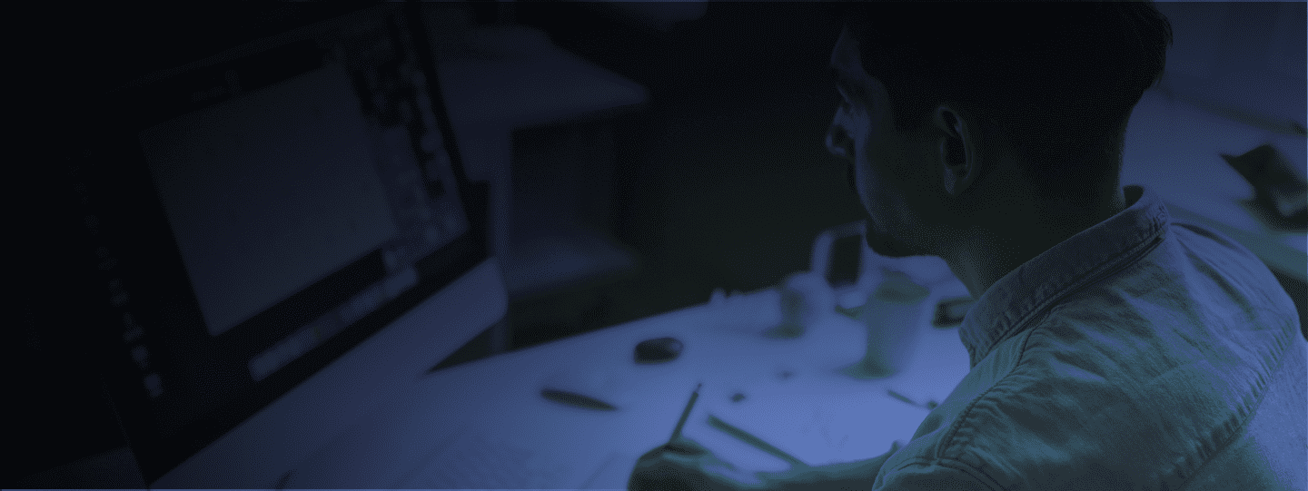 Photograph of a back's man writing on a computer with blue filter