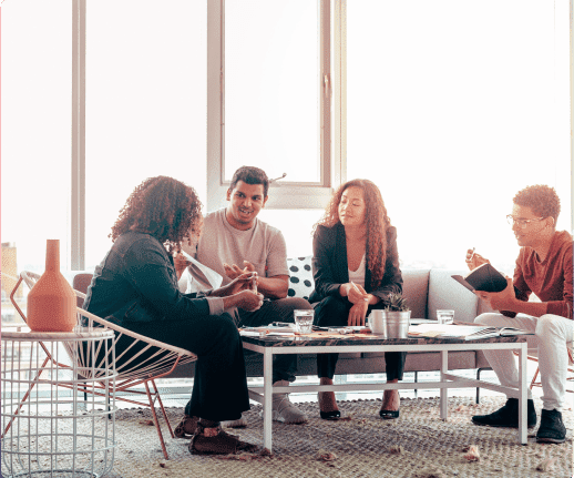 Unleashing the power of collaboration Photograph of two women and two men on a meeting with a big window on the back