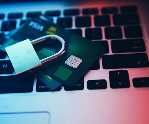 Credit card next to a padlock on the keyboard of a laptop